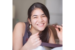 Image Teenager with great skin lying on a bed.