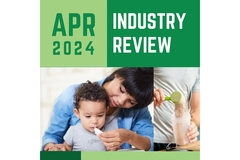 Image A graphic with a child getting fed yogurt and April In Review written in green.