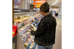 Image girl looking at a ready meal at dutch supermarket