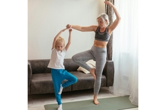 A woman and child aging and doing yoga together