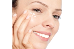Image Woman applying cream under eye