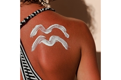 Image A woman's back with sunscreen in a wave design on her shoulder.