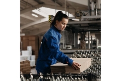 Image Woman putting cardboard onto machine.