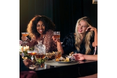 Image Two women drinking whisky inside a restaurant.