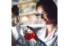 Image A scientist looks at a solution in a lab.
