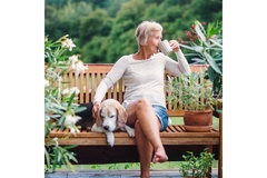Image Senior woman sitting outside, enjoying a coffee.