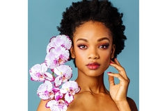 Image Woman wearing makeup poses with orchids