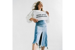 Image male with long hair carrying sign saying makeup is genderless