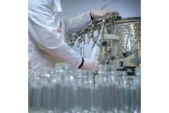 Image Filling glass bottles on machine.