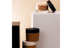 Two jars sitting on white and black platforms.
