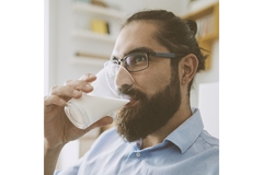 Image A man with a beard drinking milk.