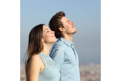Image Man and woman standing outside breathing in fresh air, looking happy.