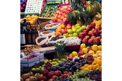 Image Fresh fruits, nuts, vegetables and olive oil displayed on a stand in an open air market.