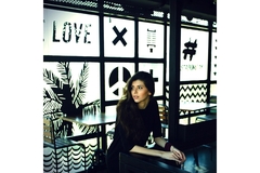 Woman leans over in a cafe.