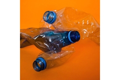 Three crushed plastic water bottles stacked on top of eachother