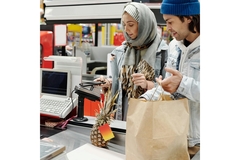 Image A couple paying at the cash counter in a supermarket.