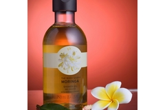 Image A product from The Body Shop next to a fake flower.