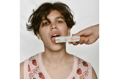 An adolescent posing with an unhealthy sandwich.