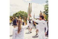 Image Two people wearing Olympic gear holding up the torch.