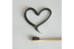 Image heart drawn with toothpaste above a toothbrush