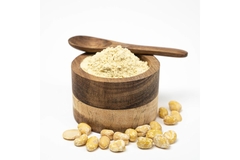 Image Fava bean protein isolate powder in a glass and beans next to it.