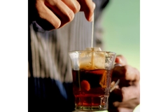 Holding tea bag in mug.