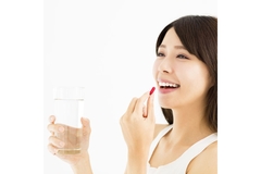 Image Smiling woman eating pill