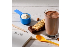Image Protein powder, shake and bar next to a notepad that says "be fit"