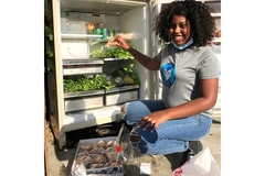 Young woman prepping the food donation fridge