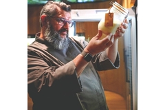 Image A man holding a glass container with sourdough culture.