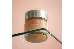 A pot of Clinique moisturizer on a glass table.