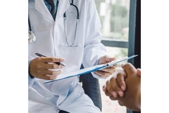 Image Doctor holding a clipboard with a report, talking to a patient.