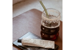Image A cup of iced coffee next to a bottle of moisturizer.