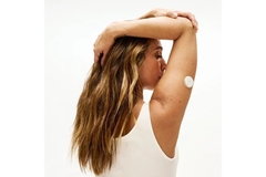 Image Woman with a glucose biosensor on her arm.