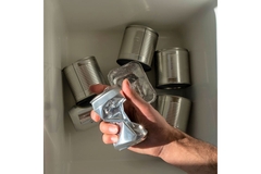Image Throwing empty metal cans in bin.