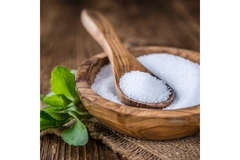 Image Stevia sweetener and leaf in a wooden bowl.