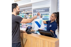 Image The Vitamin Shoppe attendant hands over consumer's purchase