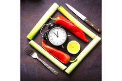 Image A clock, leeks, chili peppers, lemon and cutlery