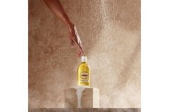 Image A hand touching a L’Occitane En Provence fragrance bottle.