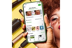 A hand holding a phone open to Sally Beauty products in the Instacart app.