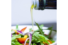 Pouring oil on salad.