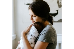 A mother cradling her baby.