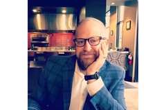 Image A man in suit sitting at the dinner table.