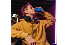 Image A young man drinking a soft drink for the can.