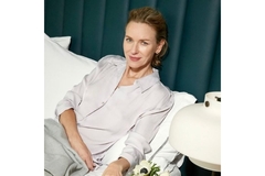 Image Naomi Watts sits on couch smiling