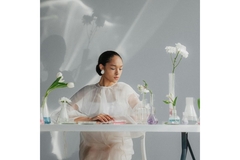 Image woman sits on table with lab vials