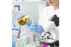 Image A scientist holding a flask of oil.