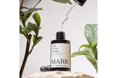 A serum from Mark surrounded by flowers.