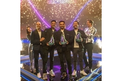 winners on stage holding award