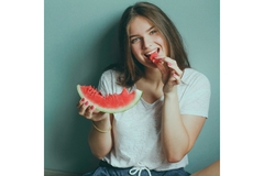 A woman eating watermelon.